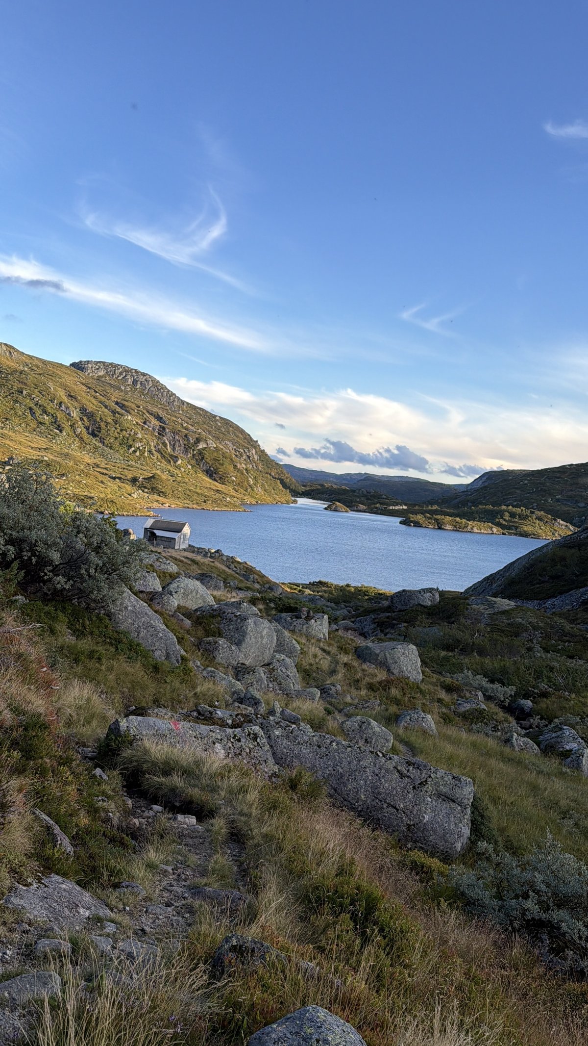 A remote mountain lake in the Setesdal high country with a small cabin on the shore